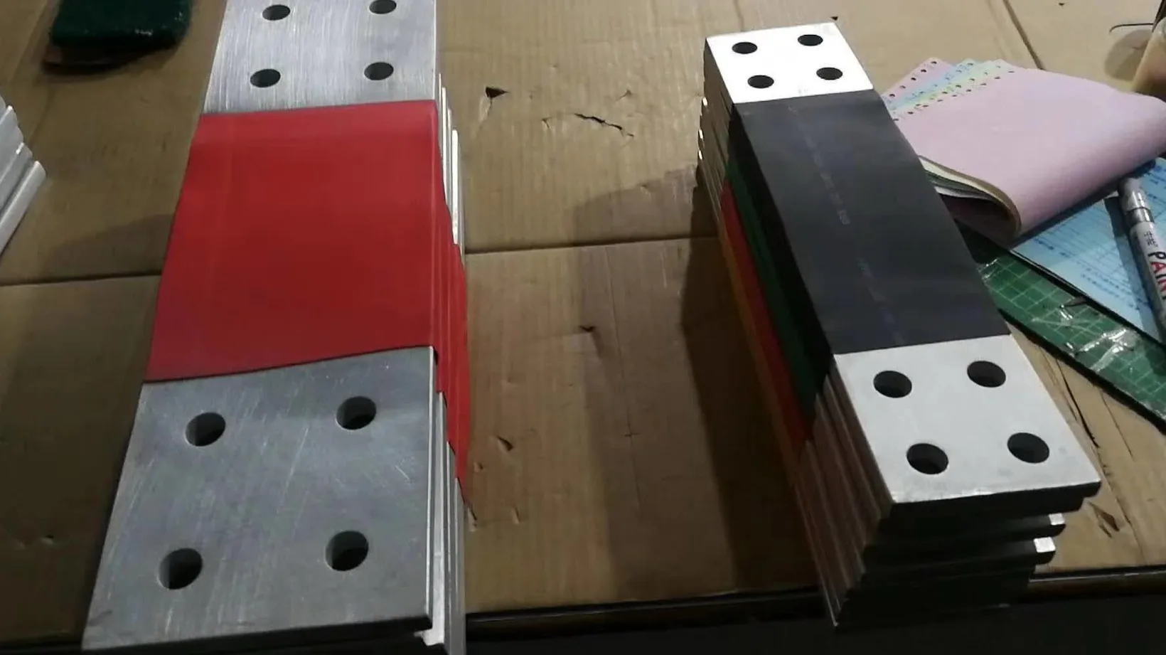 Copper busbars with heat-shrink tubing over the middle and bare drilled contact pads at both ends