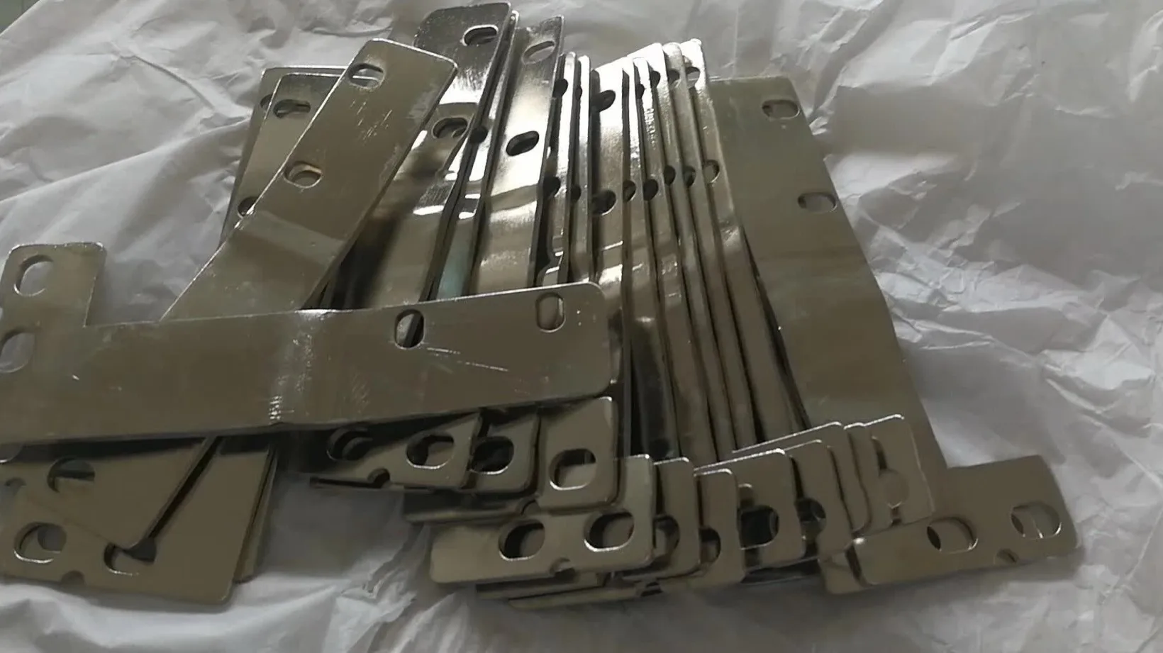 Stamped copper busbars with nickel-plated contact pads and slotted mounting holes before coating