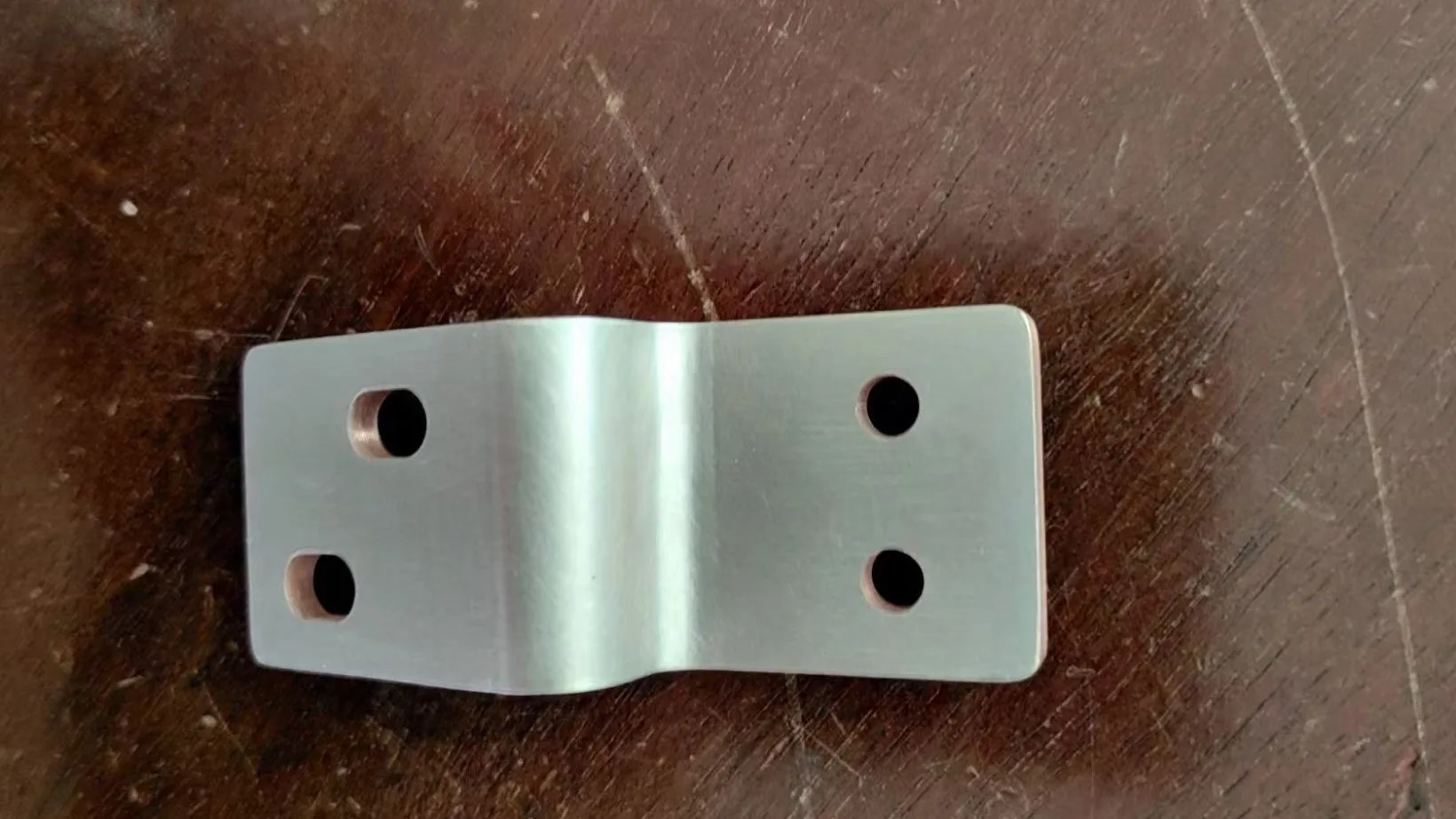 Tin-plated copper busbar with a formed Z-bend and four mounting holes before insulation