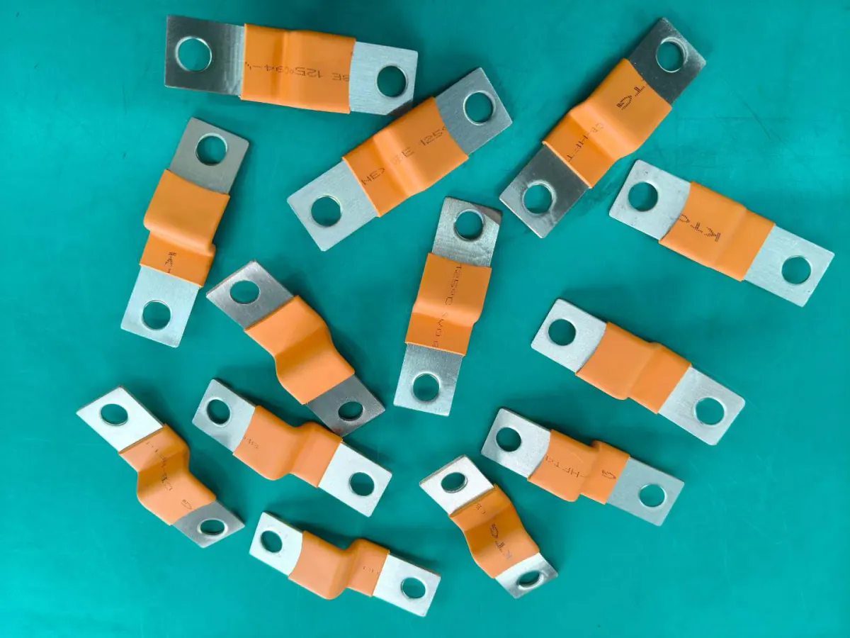 Insulated flexible copper busbars with tin-plated terminal ends laid out on a workbench