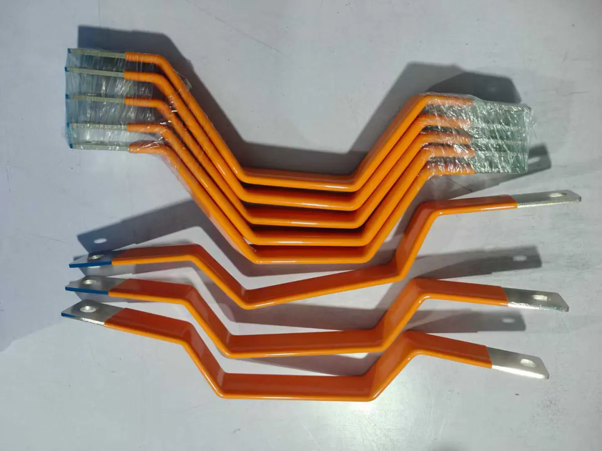 Laminated flexible copper busbars formed to an S-bend profile, insulated in orange with plated flat ends