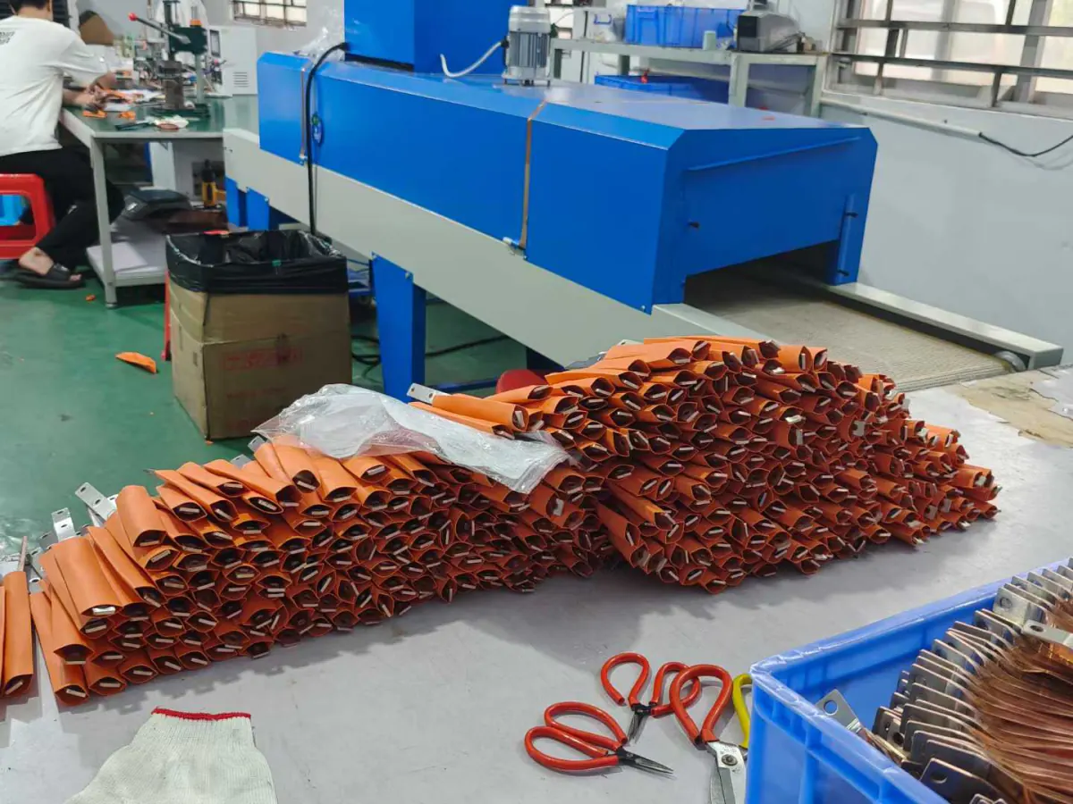 PVC dip coating line with freshly coated orange busbars leaving the curing oven